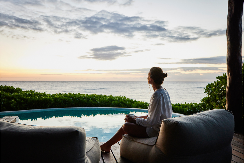 Femme voyageant seule sur une terrasse face à la mer