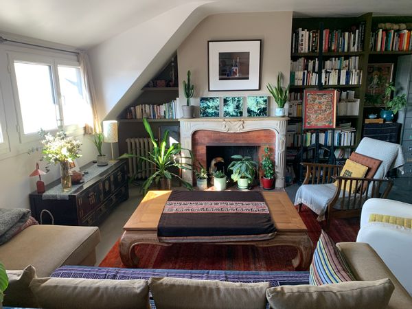 Appartement mansardé au dernier étage avec vue des toits et du ciel parisiens.