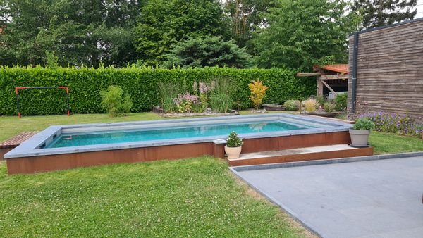 Maison familiale à la campagne avec piscine dans un agréable jardin fleuri.