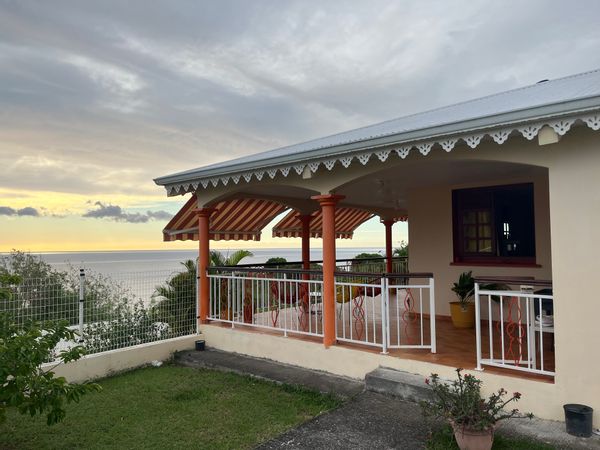 La maison de Nizou, Située  dans les hauteurs du Carbet, cette maison de plain-pied offre un cadre calme et agréable avec une vue imprenable sur la mer des Caraïbes et la Montagne Pelée. Elle dispose de 3 chambres, d’un salon, d’une salle à manger et d’une grande terrasse en U, idéale pour profiter de l’extérieur. La propriété est entourée de verdure et bénéficie d’une belle luminosité naturelle. Le logement est fonctionnel et bien ventilé, parfait pour un séjour en famille ou entre amis.