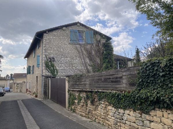 Grande maison en pierres blanches avec jardin dans un village du Beaujolais