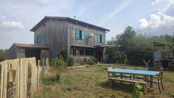 Une maison en bois au cœur d'une ferme paysanne et sauvage