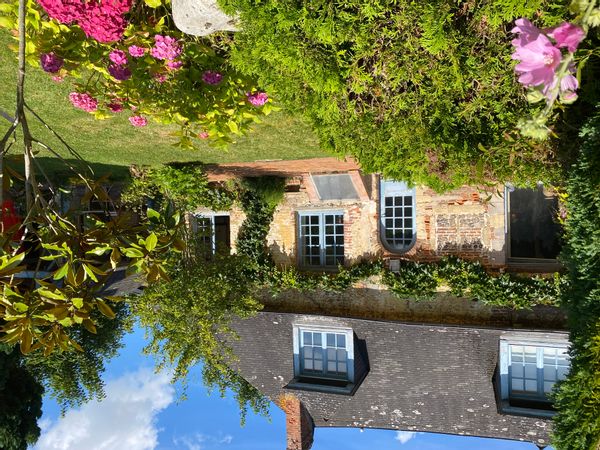 C’est une maison normande ancienne, avec sa vigne vierge et ses murs en briques et silex.