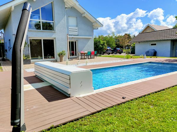 Maison moderne et colorée avec piscine, jardin et espace de jeux.