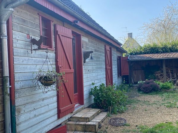 Maison en bois dans petit village avec atelier d'artiste, terrasse et jardin.