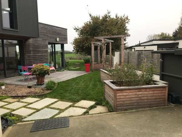 Maison contemporaine avec terrasse, espace jardin et potager.