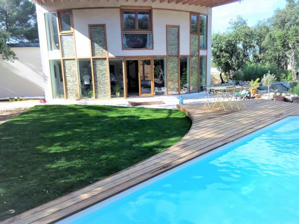 Une maison bioclimatique dans un grand jardin avec piscine