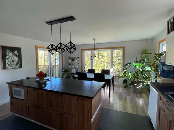 Maison bordée par une rivière au pied d'une montagne