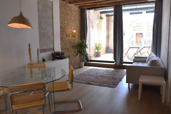 Loft chaleureux avec murs en pierre et terrasse.