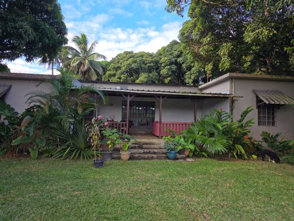 Maison tropicale au pied des montagnes, au cœur d’un grand jardin