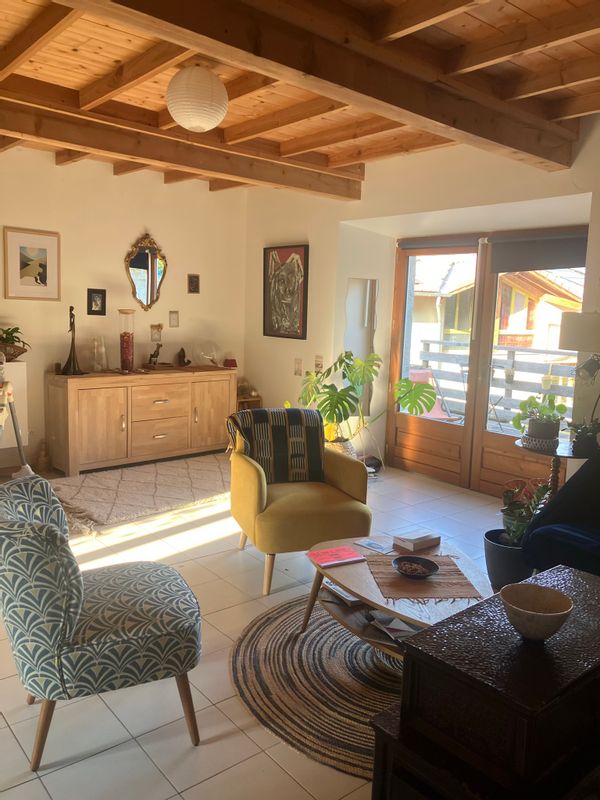 Maison à étage avec grande terrasse en bois donnant sur le jardin.
