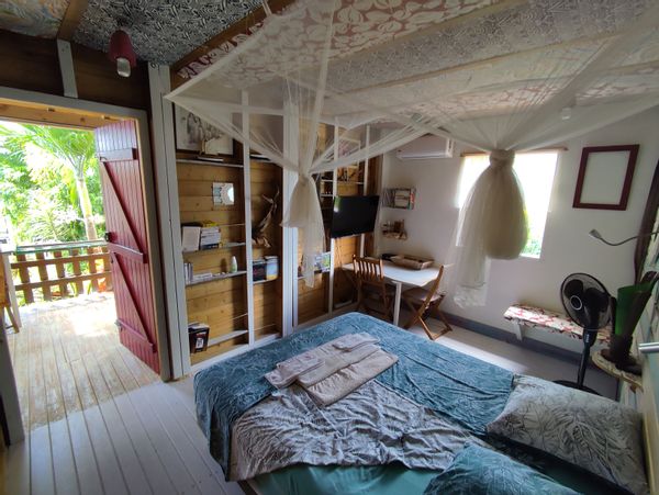 Appartement privatif avec une cuisine extérieure et un coin salon, entouré de verdure sans vis à vis