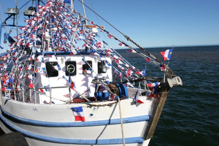Bateau de pêcheurs avec les drapeaux acadiens