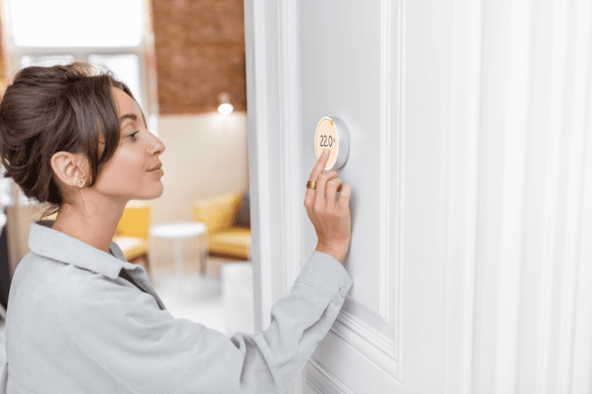 une personne règle le thermostat d'une porte blanche